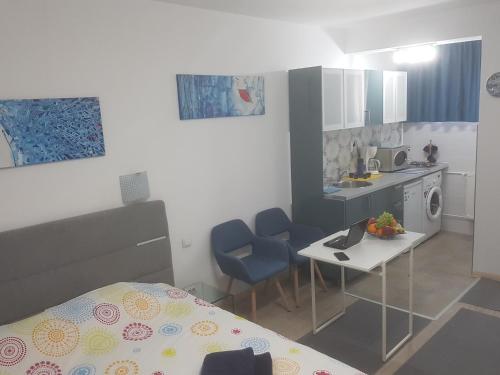 a small kitchen with a table and two blue chairs at Calea Victoriei Residence in Bucharest