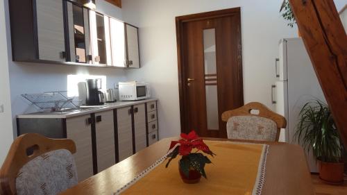 a dining room with a table and a kitchen at Casa Sara in Săcele