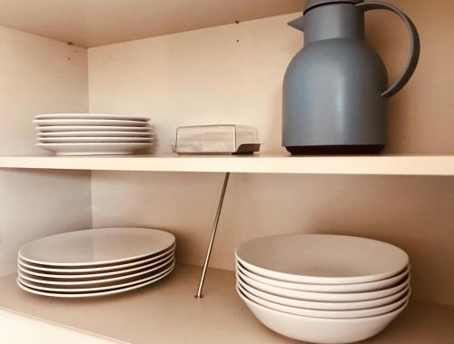 a shelf with plates and a vase on it at Ferienzimmer in Allensbach in Allensbach