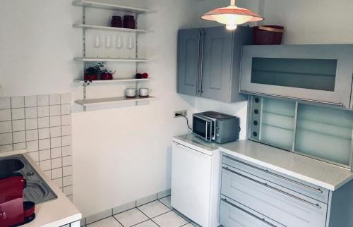 uma cozinha com armários azuis e um micro-ondas em Ferienzimmer in Allensbach em Allensbach