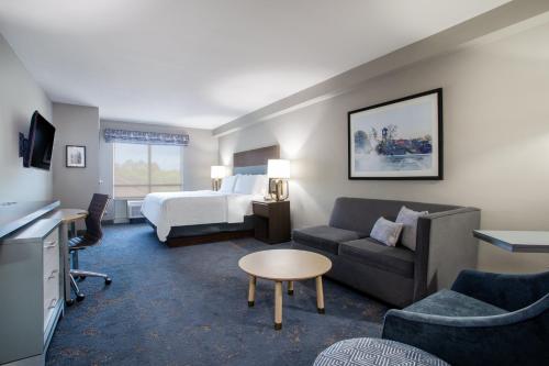 a hotel room with a bed and a couch at Holiday Inn Valdosta Conference Center by IHG in Valdosta