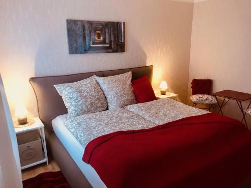 um quarto com uma cama com um cobertor vermelho em Ferienzimmer in Allensbach em Allensbach