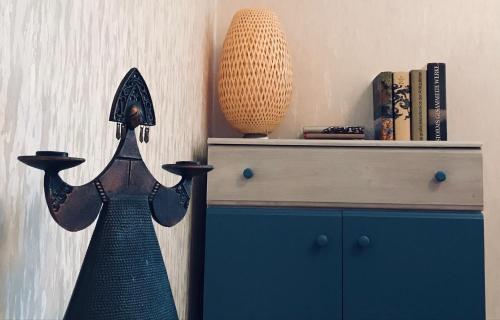 a dress on a cabinet with a vase on the wall at Ferienzimmer in Allensbach in Allensbach
