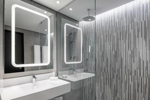 a bathroom with two sinks and two mirrors at Park Inn by Radisson, Riyadh in Riyadh