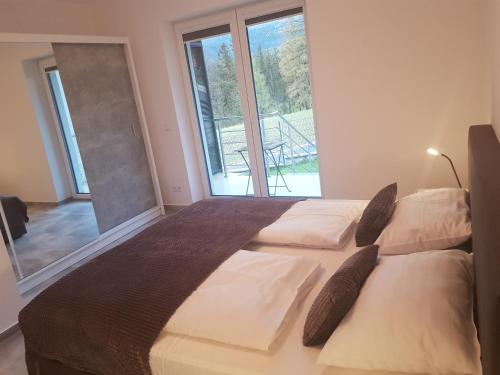 um quarto com uma cama grande e uma janela grande em Apartamenty KADO em Karpacz