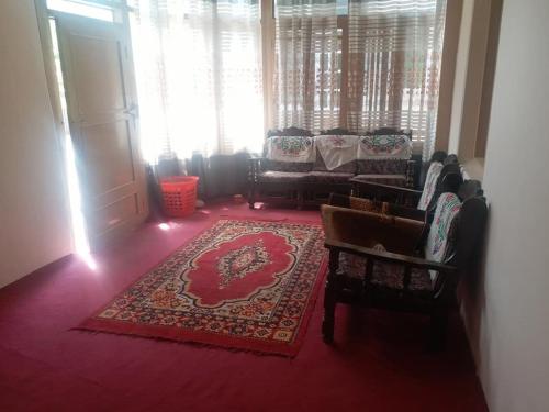 a living room with a couch and a rug at Ibadat Shah Lodges in Baltit