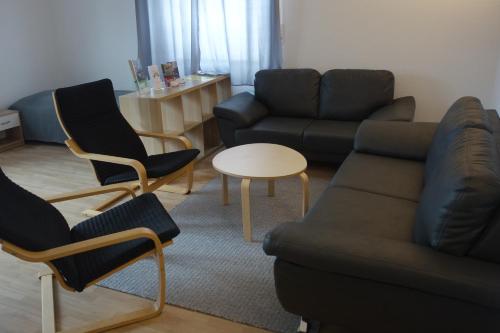 a living room with a couch and chairs and a table at Ferienwohnungen Viersen in Viersen