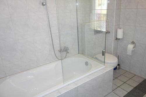 a bathroom with a shower and a tub and a toilet at Ferienwohnungen Viersen in Viersen