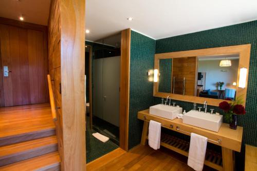 Baño con 2 lavabos y espejo en Uman Lodge Patagonia Chile, en Futaleufú