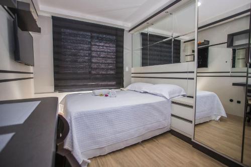 a small bedroom with a bed and a window at Studio Moderno no Centro de Curitiba - ALL1206 in Curitiba