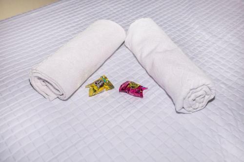 a bed with two towels and a packet on it at Studio Moderno no Centro de Curitiba - ALL1206 in Curitiba
