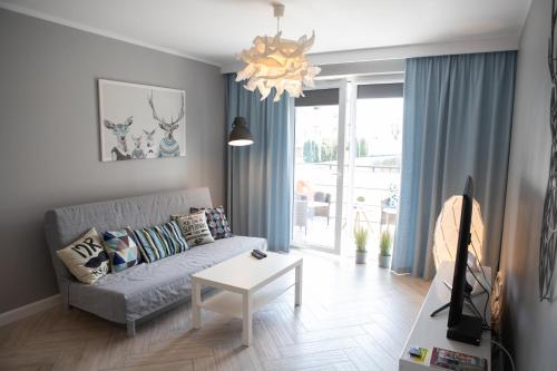 uma sala de estar com um sofá e uma mesa em Apartament Scandic em Malbork