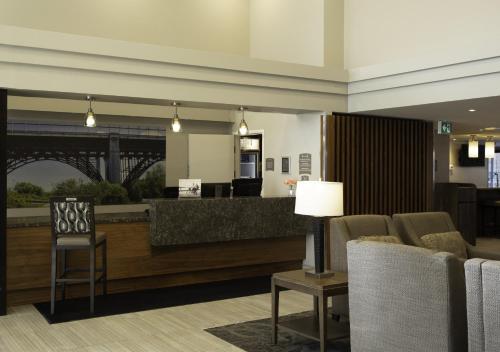 a lobby with a waiting area with chairs and a counter at Staybridge Suites Toronto - Vaughan South by IHG in Vaughan