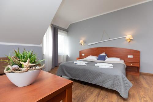 a bedroom with a large bed and a table at Villa Livia in Niechorze