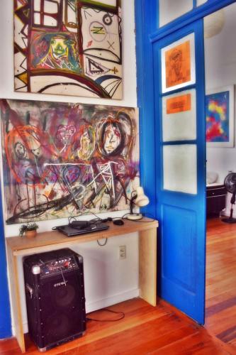 a room with a painting on the wall and a door at Brasileranza Hostel in Niterói
