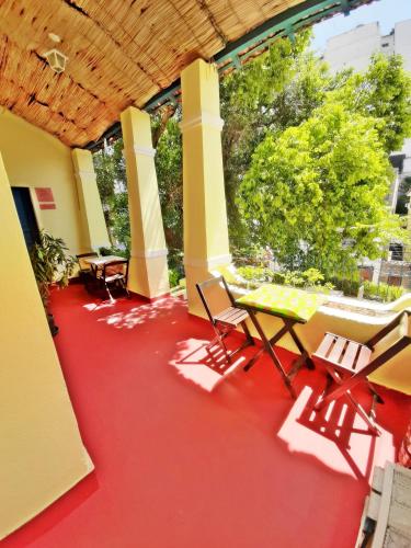 a room with tables and chairs on a red floor at Brasileranza Hostel in Niterói