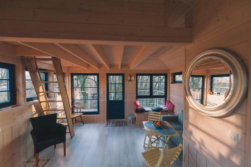 Cette chambre est dotée de murs en bois et d'une fenêtre ronde. dans l'établissement Węgiełek Treehouse, à Kazimierz Dolny