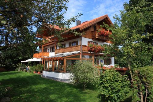 une grande maison avec une pelouse devant elle dans l'établissement Gästehaus Burgmayr, à Sauerlach