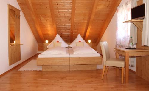 a bed in a room with a wooden ceiling at Gästehaus Burgmayr in Sauerlach