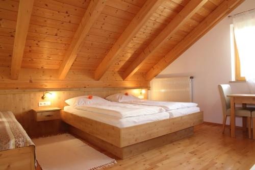 a bed in a room with a wooden ceiling at Gästehaus Burgmayr in Sauerlach