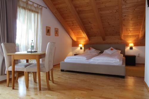 a bedroom with a bed and a table and chairs at Gästehaus Burgmayr in Sauerlach