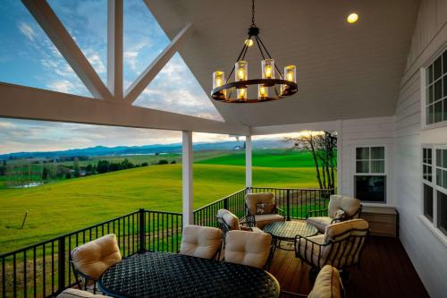 a screened in porch with chairs and a table and a chandelier at The Farmhouse at Quandary Vineyards in Carlton