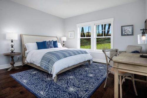 a bedroom with a bed and a table and a desk at The Farmhouse at Quandary Vineyards in Carlton