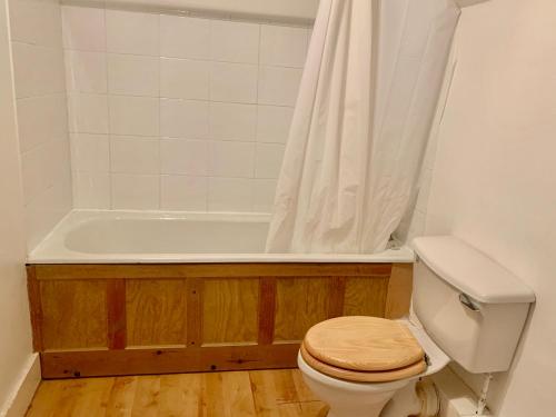a bathroom with a toilet and a bath tub at Lavender Cottage in Hereford