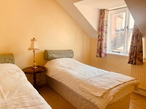 a bedroom with two beds and a window at Lavender Cottage in Hereford