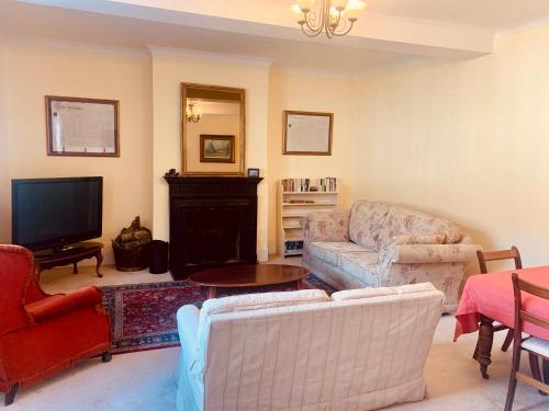 a living room with a couch and a tv at Lavender Cottage in Hereford
