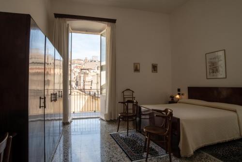 a bedroom with a bed and a large window at Hotel AeR BJ Vittoria in Cagliari