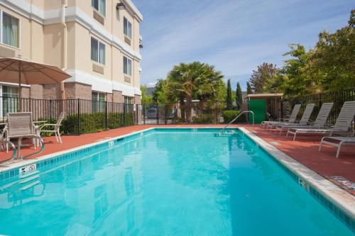 a swimming pool with chairs and a building at Holiday Inn Express Hotel & Suites Livermore, an IHG Hotel in Livermore