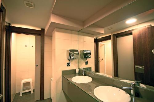 a bathroom with two sinks and a large mirror at Zubimuxu Aterpea in Goizueta