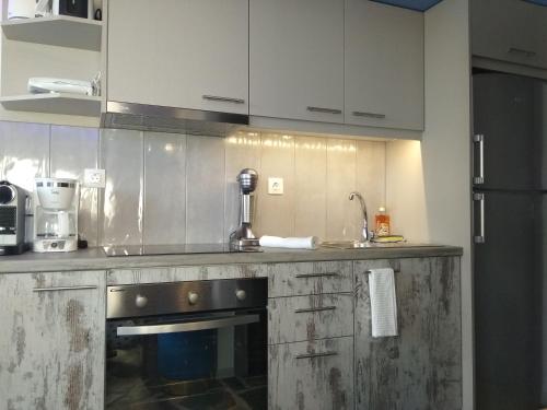 a kitchen with white cabinets and a black oven at 3SSS Bouquet Studios SEA in Marmarion