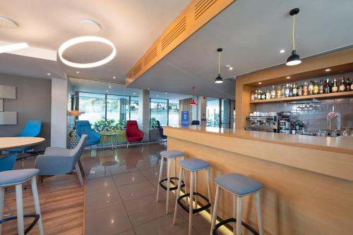 a bar in a restaurant with blue stools at Holiday Inn Express Lisbon Airport, an IHG Hotel in Lisbon