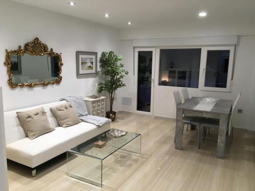 a living room with a white couch and a table at Playa del Puntal Villaviciosa Asturias Lujo Primera Linea Playa in Villaviciosa