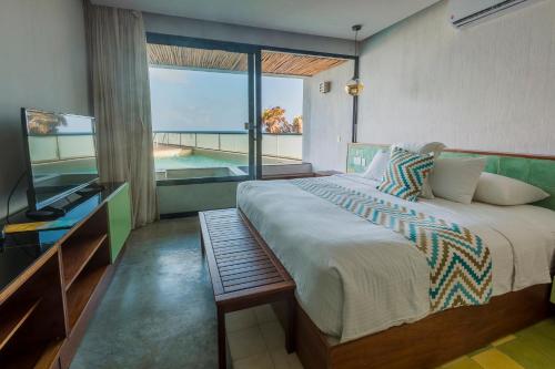a bedroom with a large bed and a large window at O' Tulum Boutique Hotel - Adults Only in Tulum