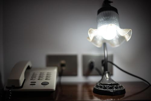 a lamp on a desk next to a telephone at Hotel AeR BJ Vittoria in Cagliari