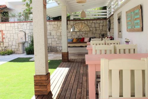 une terrasse avec une table et des chaises roses dans l'établissement Villamer Alaçatı, à Alaçatı