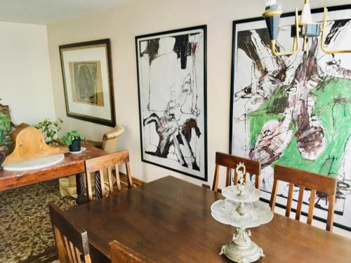 una sala da pranzo con tavolo, sedie e dipinti di Apart Hotel Curicó a Curicó