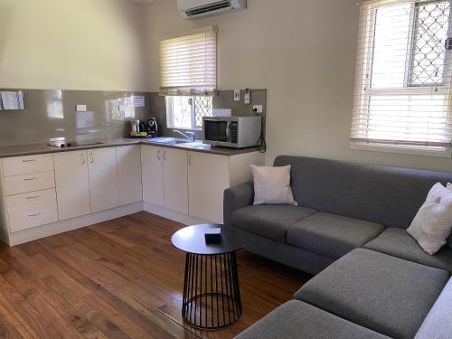 a living room with a couch and a kitchen at NRMA Atherton Tablelands Holiday Park in Atherton