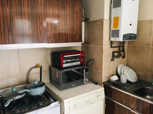 cocina pequeña con microondas y fogones en Apart Hotel Curicó, en Curicó