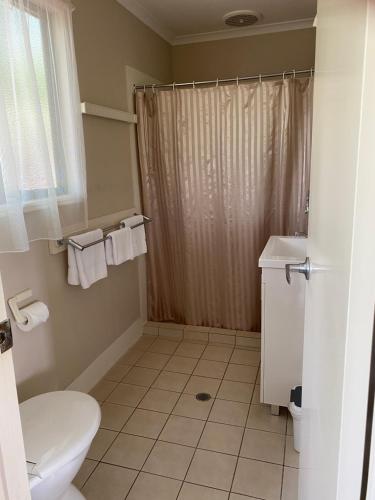 a bathroom with a white toilet and a shower at NRMA Atherton Tablelands Holiday Park in Atherton