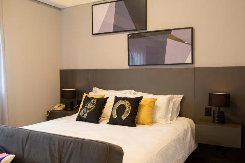 a bedroom with a bed with a television on the wall at BEN - Flats Completos com Limpeza Diária e Estacionamento Incluso in Sao Paulo