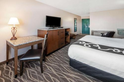 a hotel room with a bed and a desk with a television at La Quinta by Wyndham Belgrade - Bozeman Airport in Belgrade