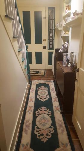 a hallway with a staircase with a rug on the floor at A Meadow House in Lakeville
