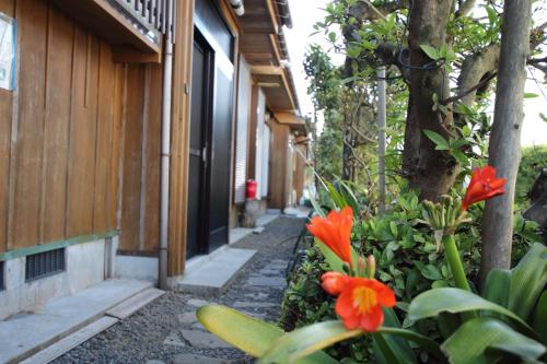 a building with orange flowers in front of a building at Yakusugi House in Yakushima