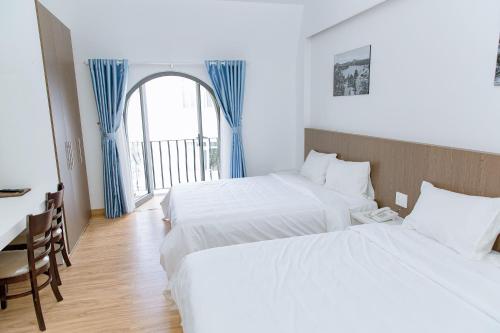 Cette chambre comprend 2 lits et une fenêtre. dans l'établissement KHÁCH SẠN ĐẠT THỊNH, à Đà Lạt