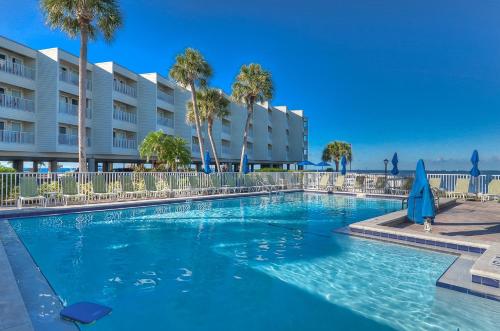 a swimming pool with palm trees and a building at 412-AMAZING Views, Waterfront, WIFI, Pool, Close to BUCS Stadium in Tampa