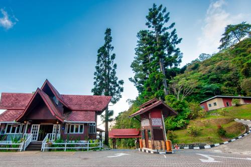 a building with a red roof on top of a hill at Sutera Sanctuary Lodges At Kinabalu Park in Kundasang